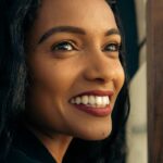 Close-up portrait of a smiling woman with a vibrant smile and warm lighting, captured in Addis Ababa, Ethiopia.