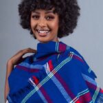 Portrait of a smiling Ethiopian woman wearing colorful traditional attire. Studio shoot.